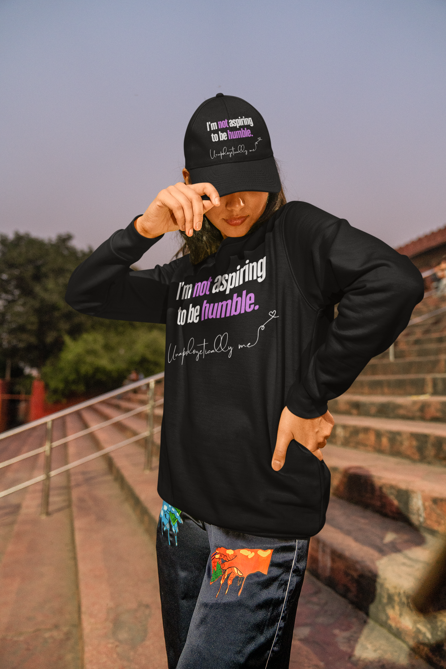 Model wearing the sweatshirt, illustrating how it can be styled casually with jeans and classic dad hat.