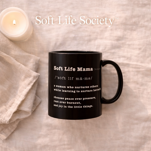 Black mug with 'Soft Life Mama' definition text on a beige background with a candle.