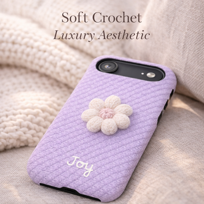 Purple textured phone case with a white flower design and 'Joy' text on a soft fabric background.