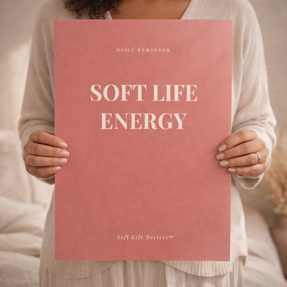 Person holding a pink poster titled 'Soft Life Energy' by Soft Life Society.